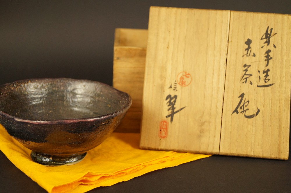 Raku ware tea bowl with opened storage box front view with storage box