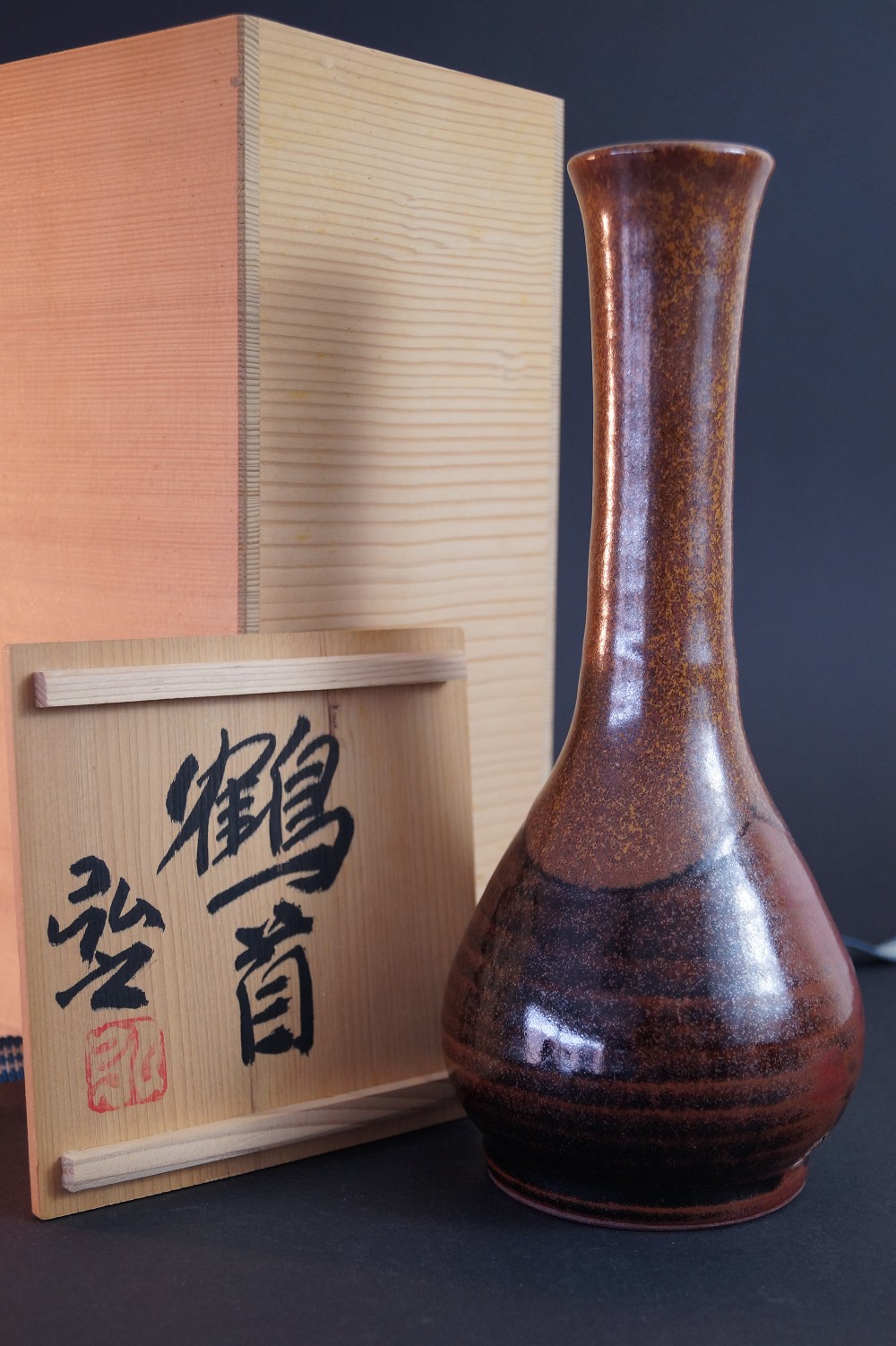 The vase next to the signed storage box inscribed Tsurukubi