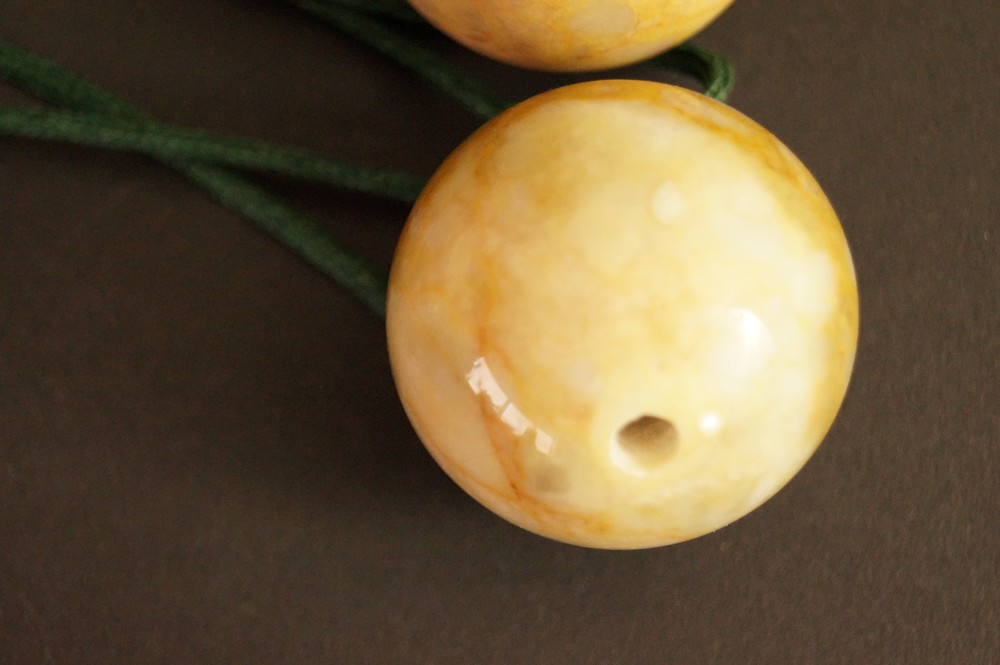 Yellow marbled stone sphere with red veining stone close-up 3