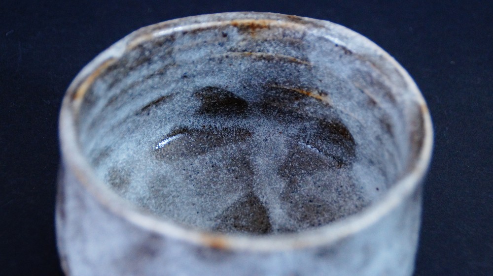 View from above of the rim and inner wall of the chawan made of Shino ware by Kazufumi Wada with dark iron spots