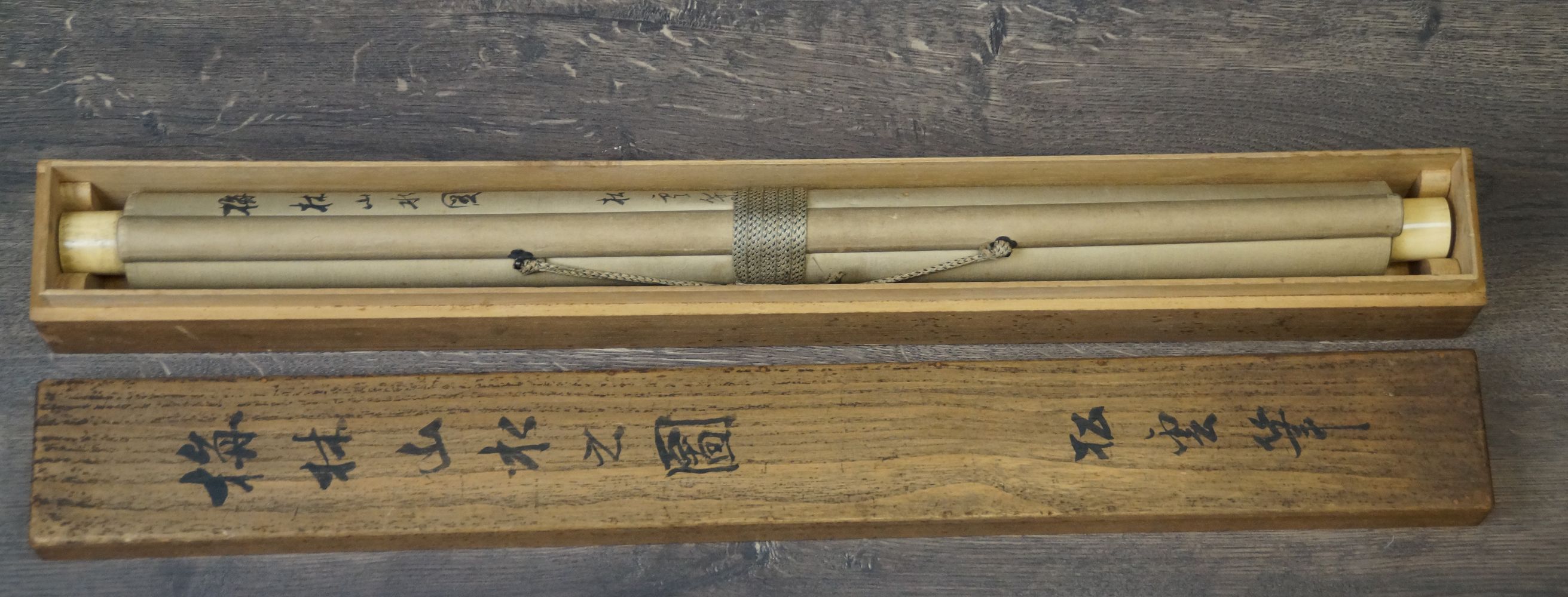 Zusammengerolltes Kakemono Pflaumenblueten im Mondnebel in der geoeffneten Aufbewahrungsbox