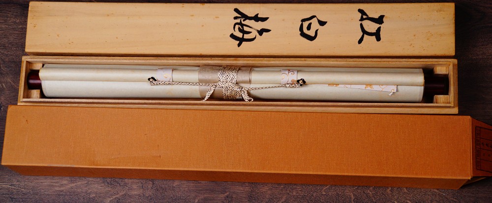 Rolled up and cord-tied hanging scroll Heralds of Spring by Koizumi Kogetsu in the opened storage box with the ink inscription Kohaku-ume on the lid
