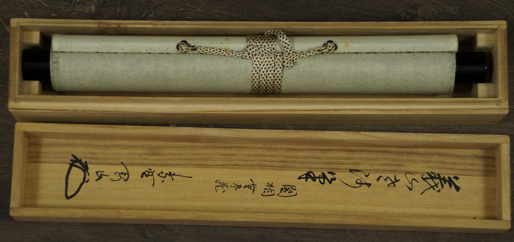 Rolled-up kakemono in the labeled storage box with cord