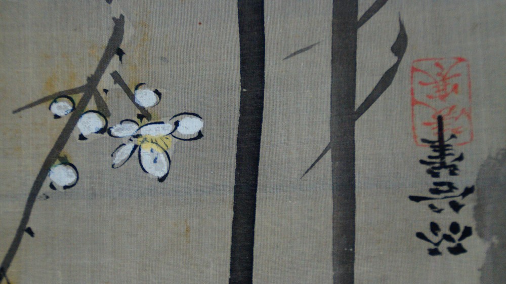 Further close-up of the white plum blossoms next to bamboo stalks and a red seal
