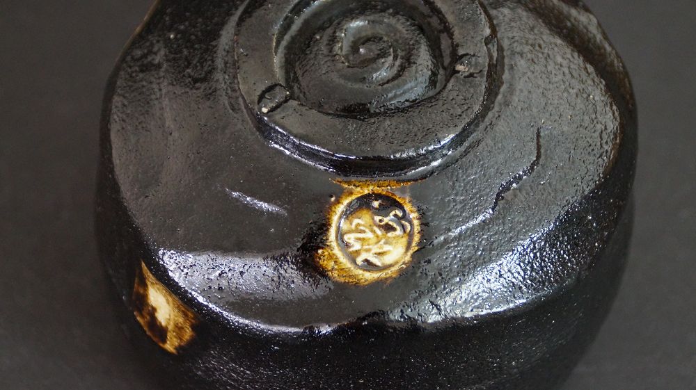 Detail view of the foot with impressed artist's seal of the chawan made of Raku ware