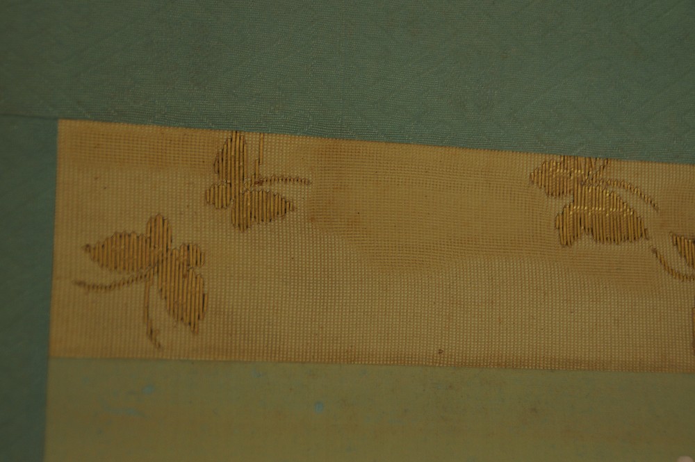 Close-up of the gold-colored border with a woven butterfly pattern