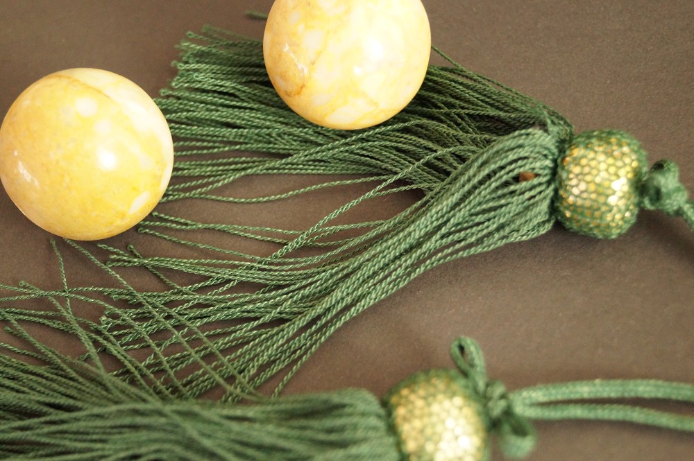 Two Stone Balls Resting on Green Silk Tassels Set Front View 2