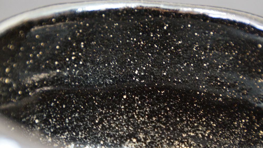 Close-up of the rim with finely speckled black interior glaze of the chawan made of Raku ware