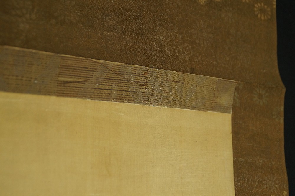 Detail shot of the mounting with brown brocade in a delicate blossom pattern
