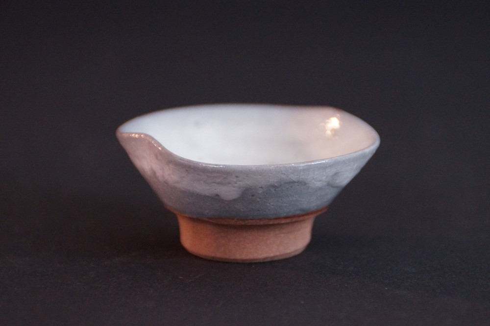 Side view of the guinomi with bluish-gray glaze and red clay body at the foot