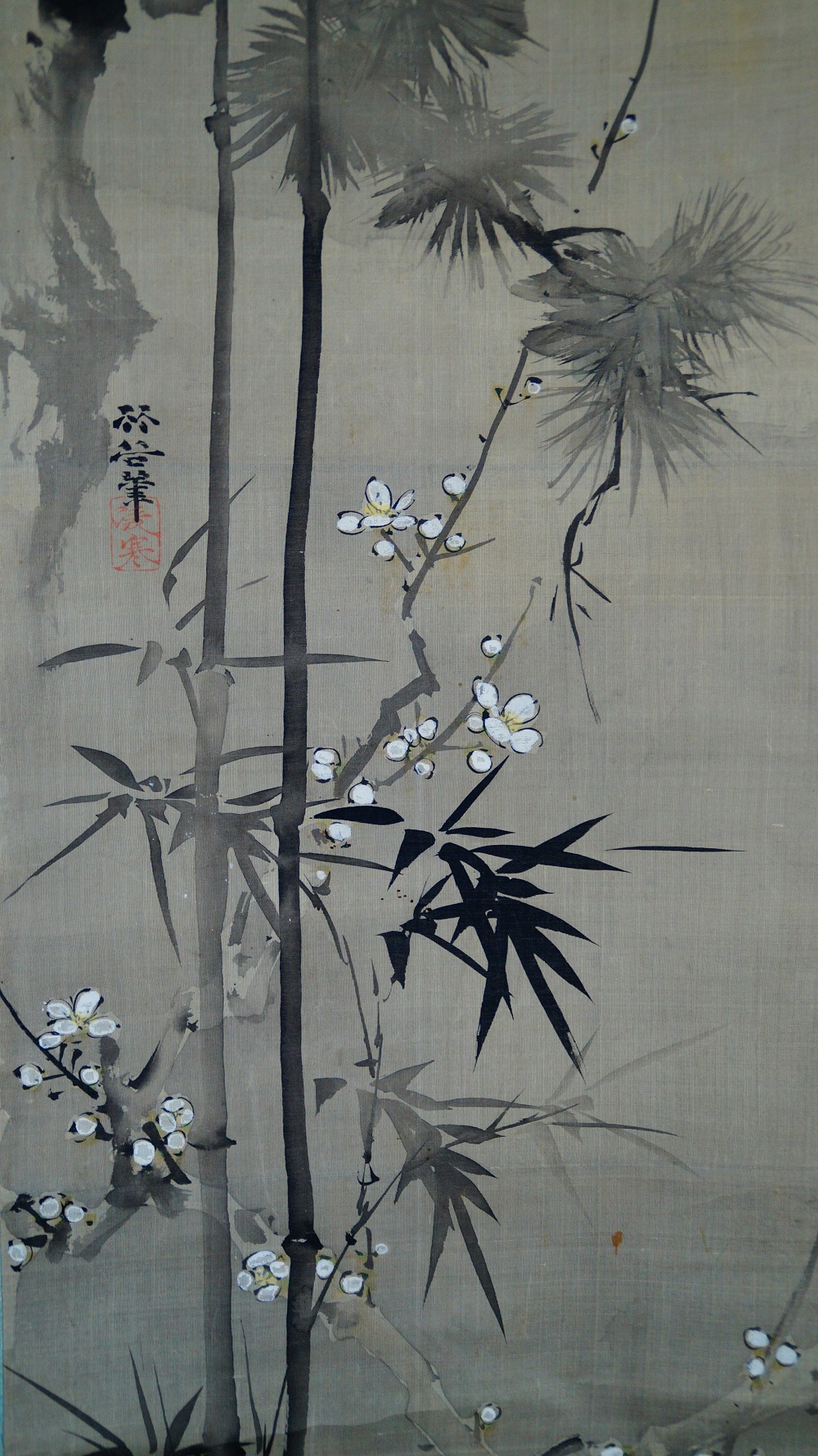 Close-up of the signature and the red artist seal next to bamboo and plum blossom