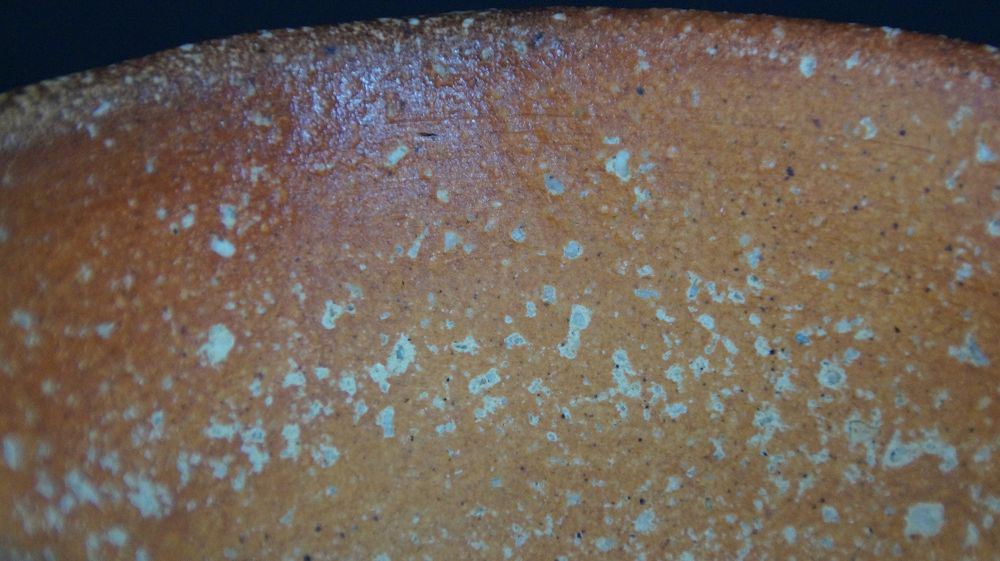 Extreme close-up of the reddish-brown fire skin with feldspar inclusions of the chawan made of Shigaraki ware