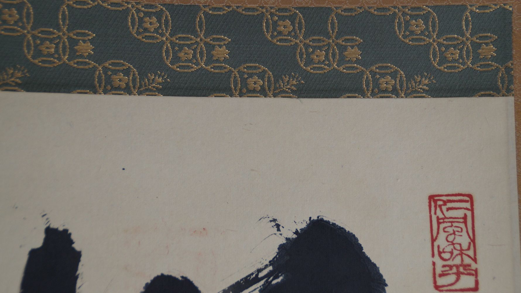 Detail view of the green brocade mounting with gold pattern at the top edge of the hanging scroll Zen Calligraphy Mu Emptiness