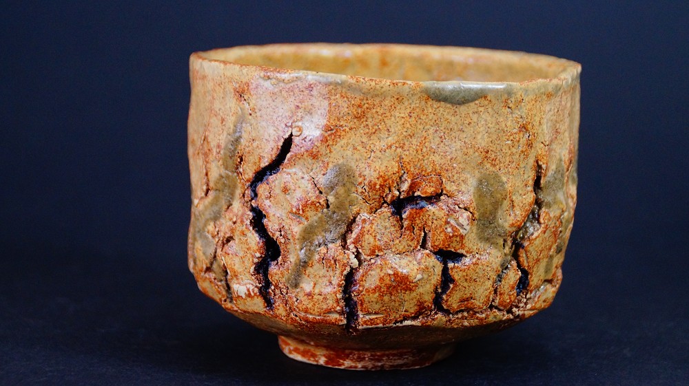 Chawan made of Seto ware by Takamichi Kato in frontal view with ochre-colored, deeply crackled glaze