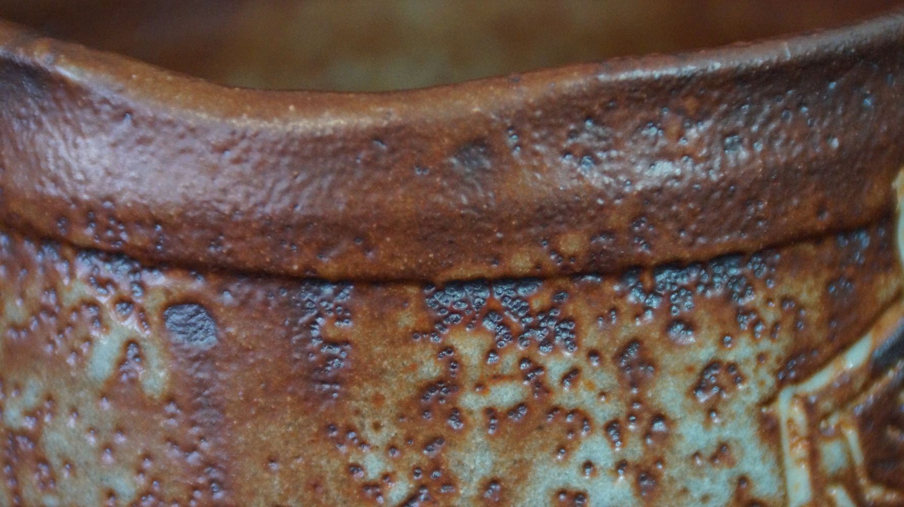 Further close-up of the rim with greenish speckled glaze of the chawan tea bowl made of Shino ware