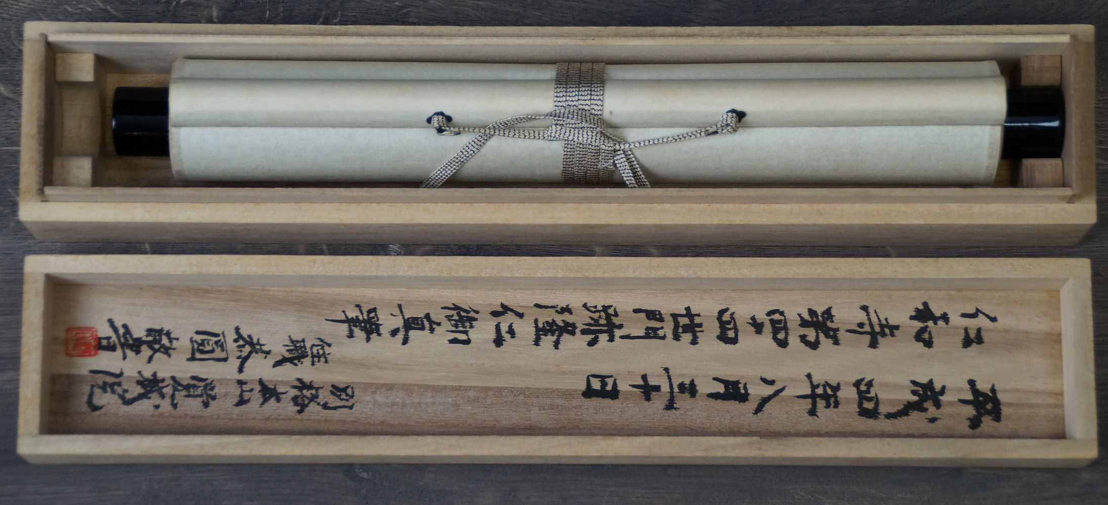 Rolled-up Kakemono Zen Calligraphy Mu Emptiness in the opened storage box