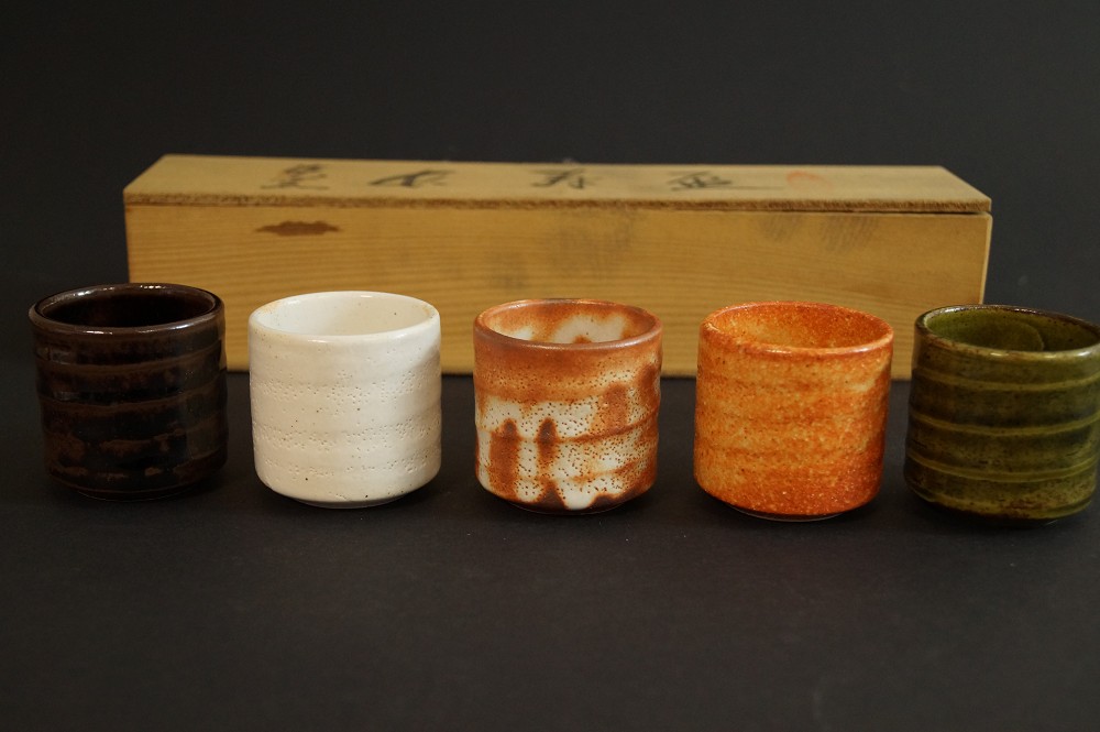 Five sake cups in front of the labeled storage box set front view with storage box 1