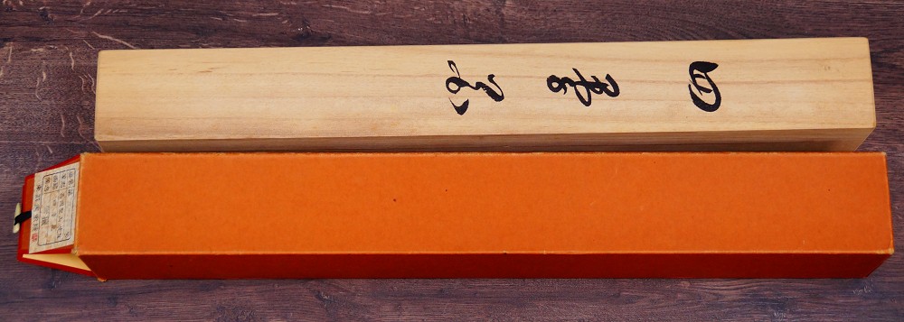 Close-up of the ink inscription on the lid of the light wood storage box
