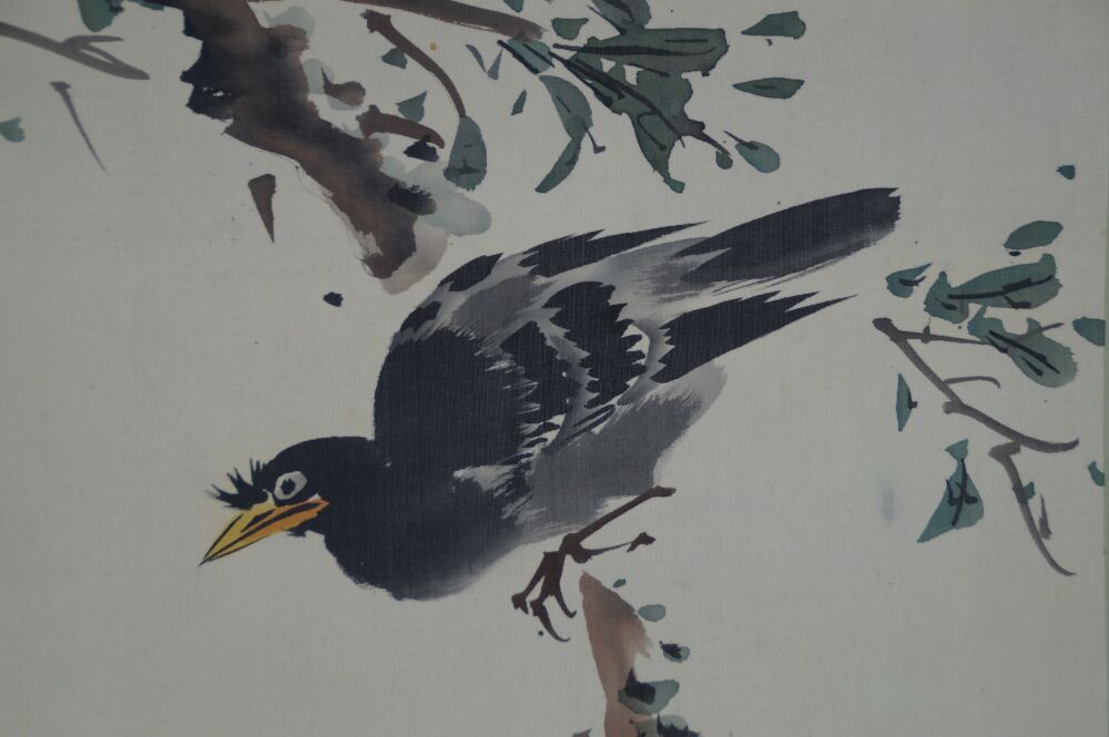 Close-up of the starling perched on a branch among leaves in the Kakemono Pomegranate Branch and Starling