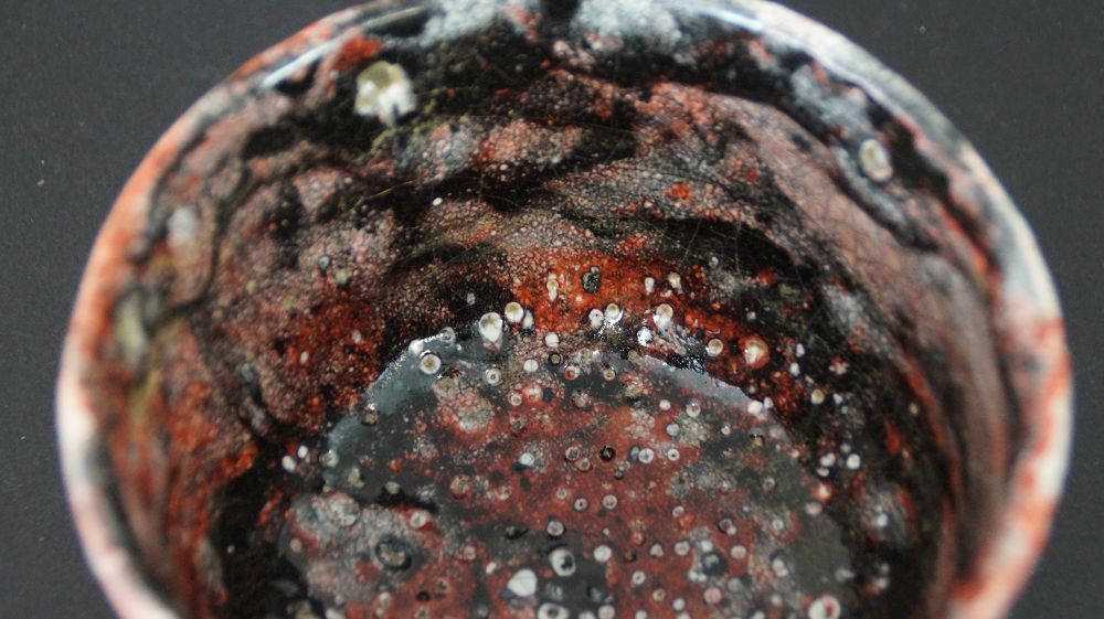 Close-up of the colorfully speckled interior glaze of the chawan tea bowl made of Raku ware