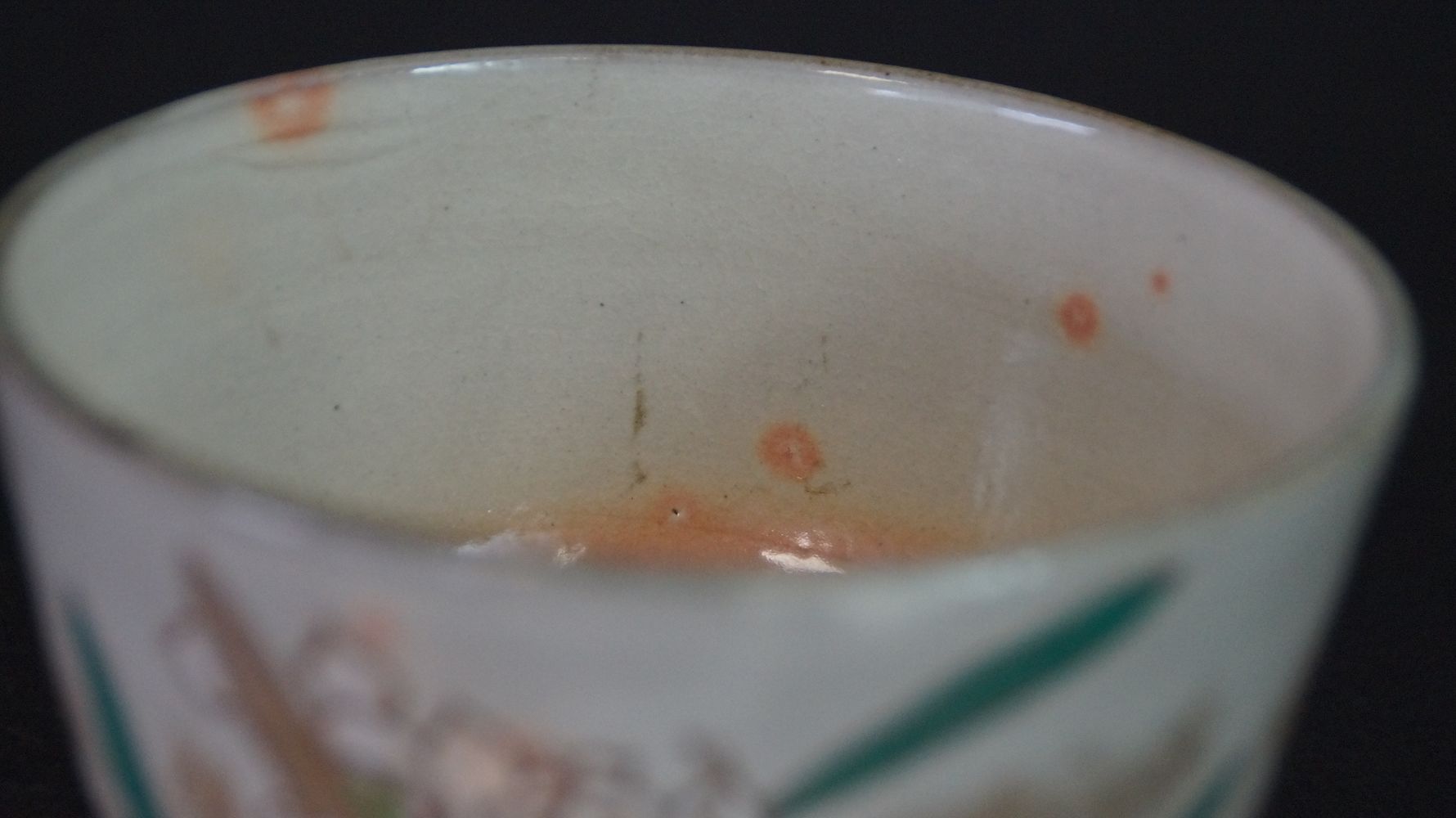Close-up of the cream-colored interior glaze with orange spots of the chawan tea bowl made of Kyoto ware