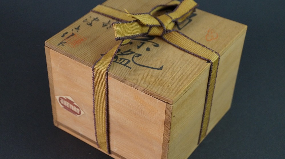 Closed storage box made of kiri wood with golden cord tie and ink inscription