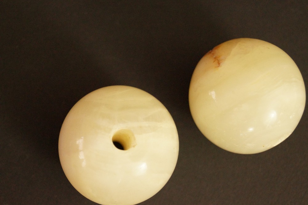 Two light-colored natural stone spheres, one with reddish-brown veining, Stone Close-Up 4