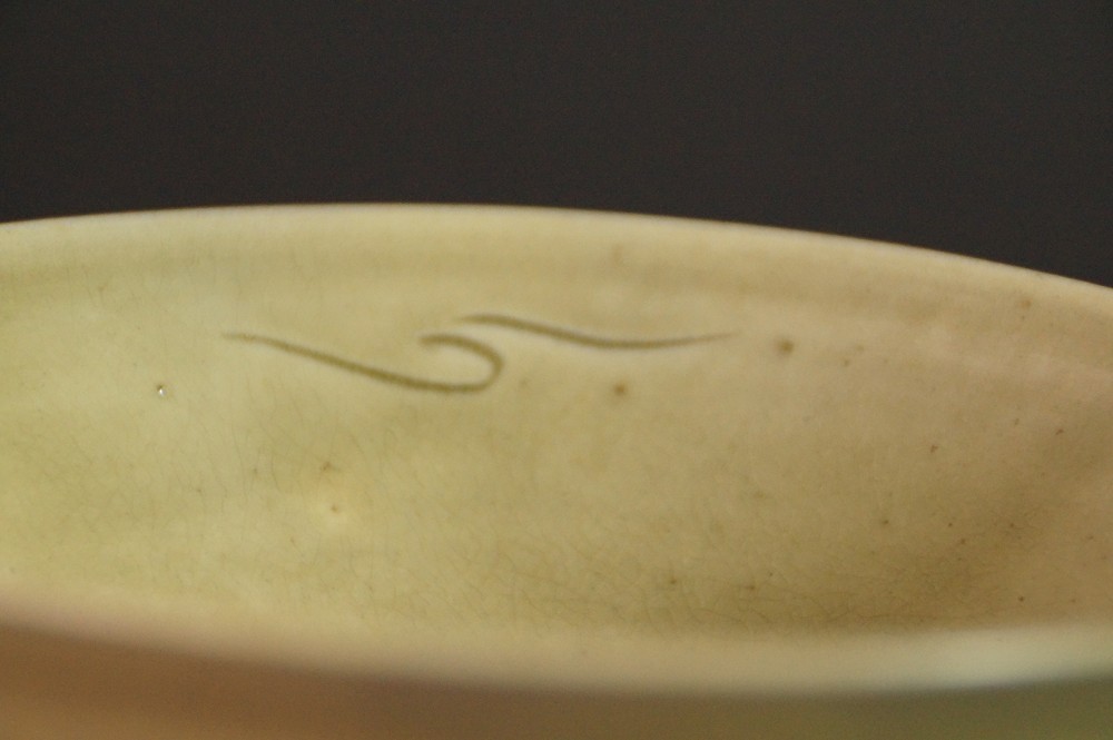 Close-up of the crackled green glaze with curved incised line on the inside