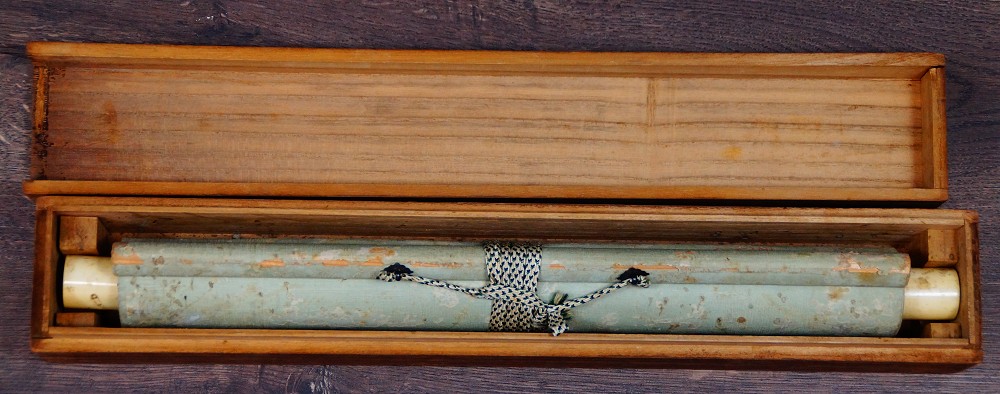 Rolled-up hanging scroll by Nishioka Sosen with cord tie in the open storage box