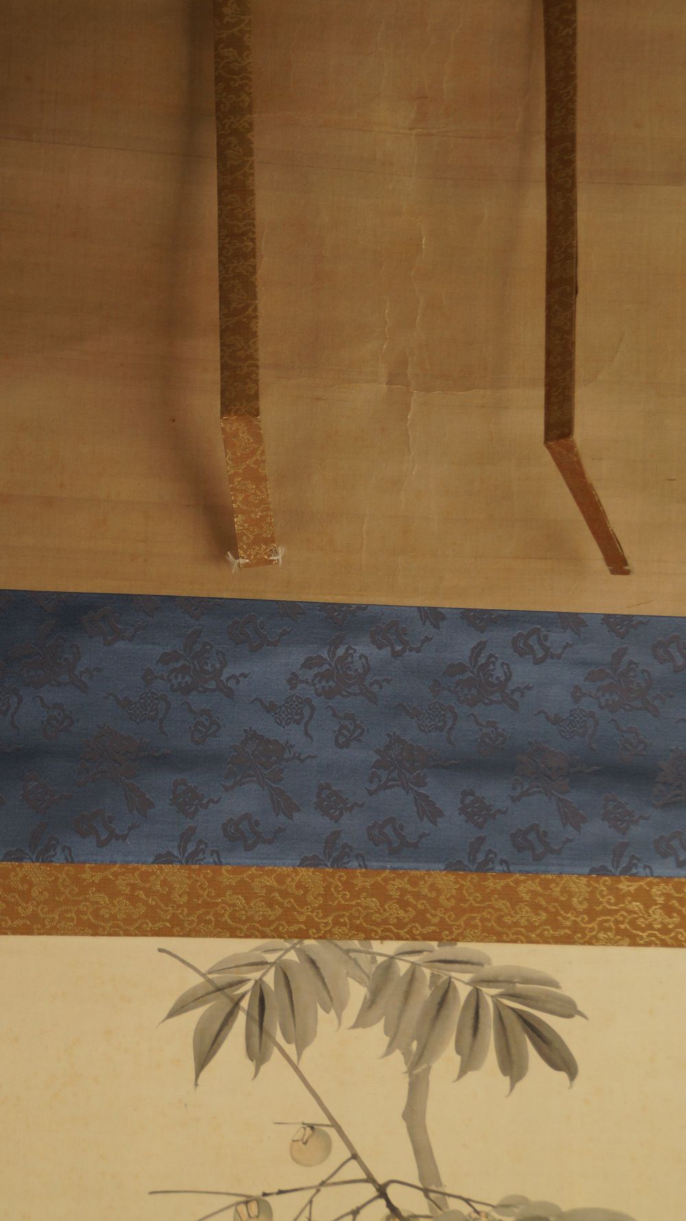 Detail view of the hanging scroll cords and the blue brocade mounting of the hanging scroll Bird on Fruit Tree