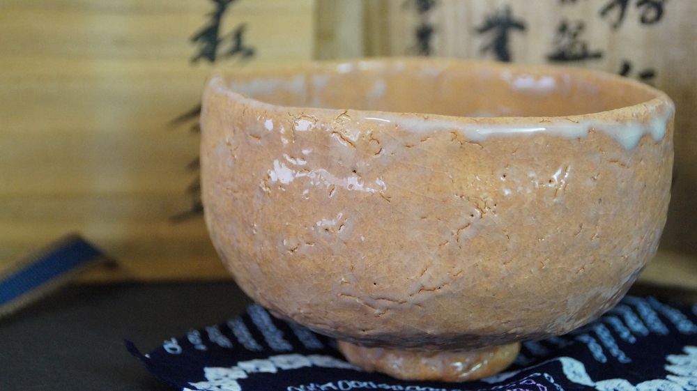 Chawan Made of Hagi Ware Next to the Signed Storage Box on Blue Patterned Cloth