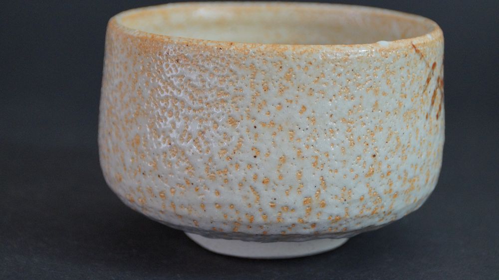 Back of the chawan made of Shino ware with orange fire trail on white glaze