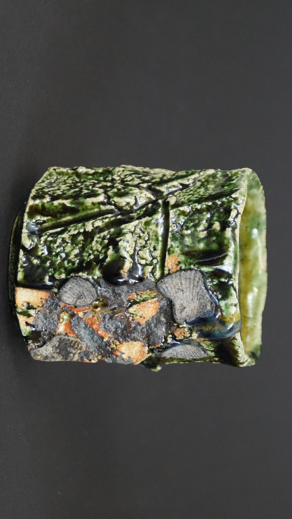 Additional view of the yunomi tea bowl made of Oribe ware with stone-like inclusions and orange accents