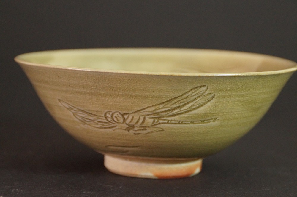 Side view of the green Tada ware tea bowl with incised dragonfly motif