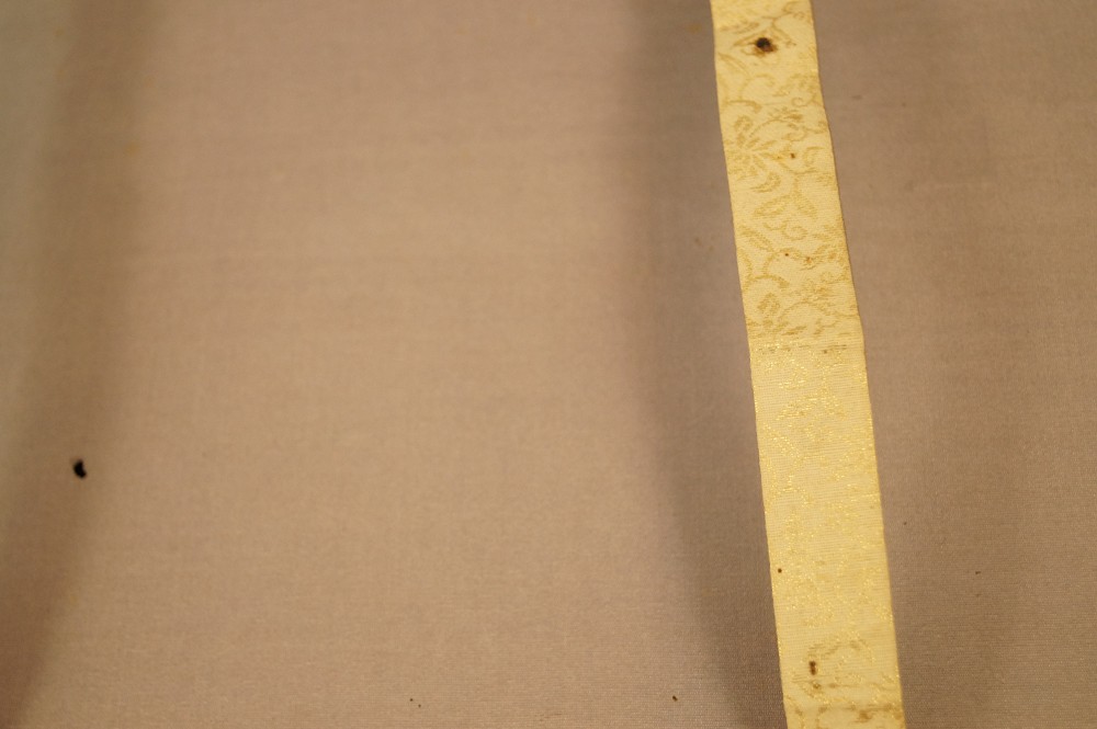 Cream-colored hanging band with floral brocade pattern mounting detail