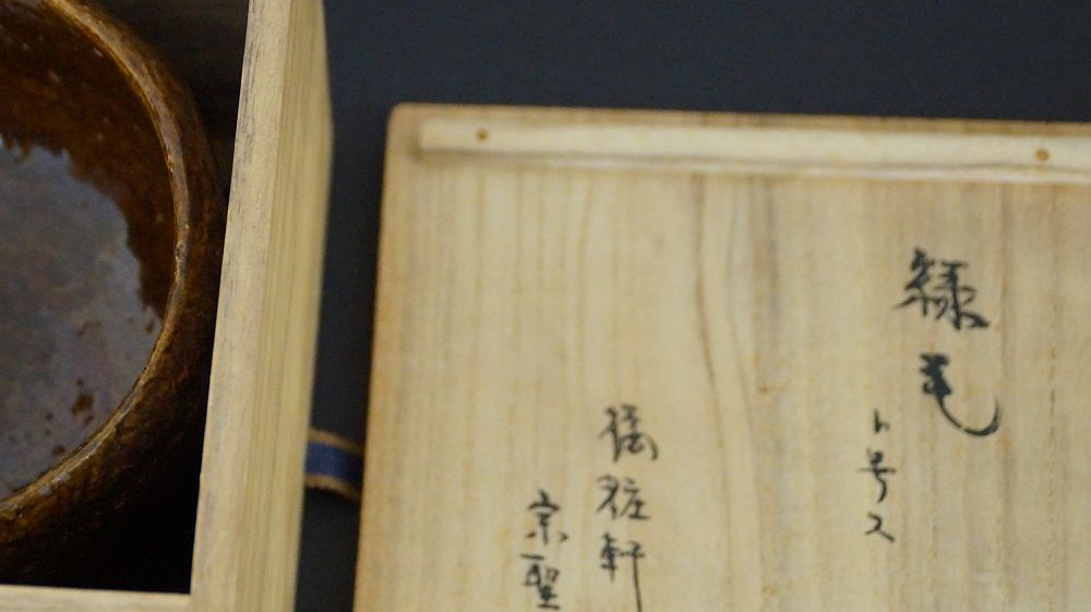Detailansicht der Kuenstlersignatur auf dem Kastendeckel der Chawan Teeschale aus Raku-Keramik