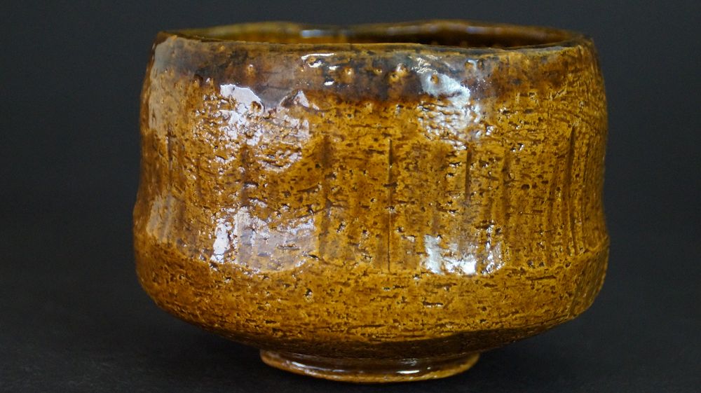 Additional view of the chawan made of Raku ware with vertical grooves in the glaze