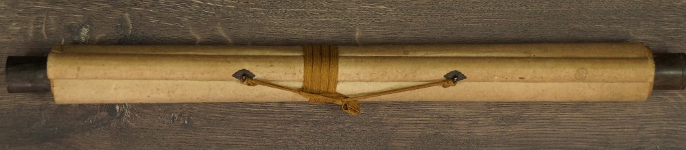 Zusammengerolltes und mit Kordel verschnuertes Kakemono mit Jikusaki aus Holz