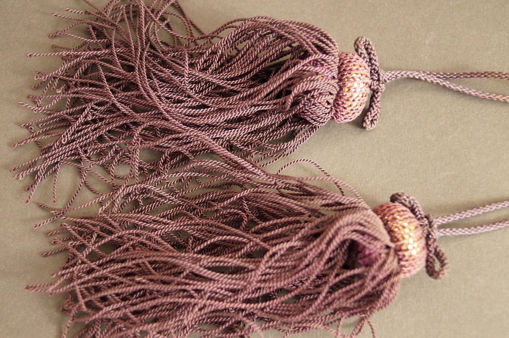 Mauve-colored silk tassels with gold-colored beads tassel close-up