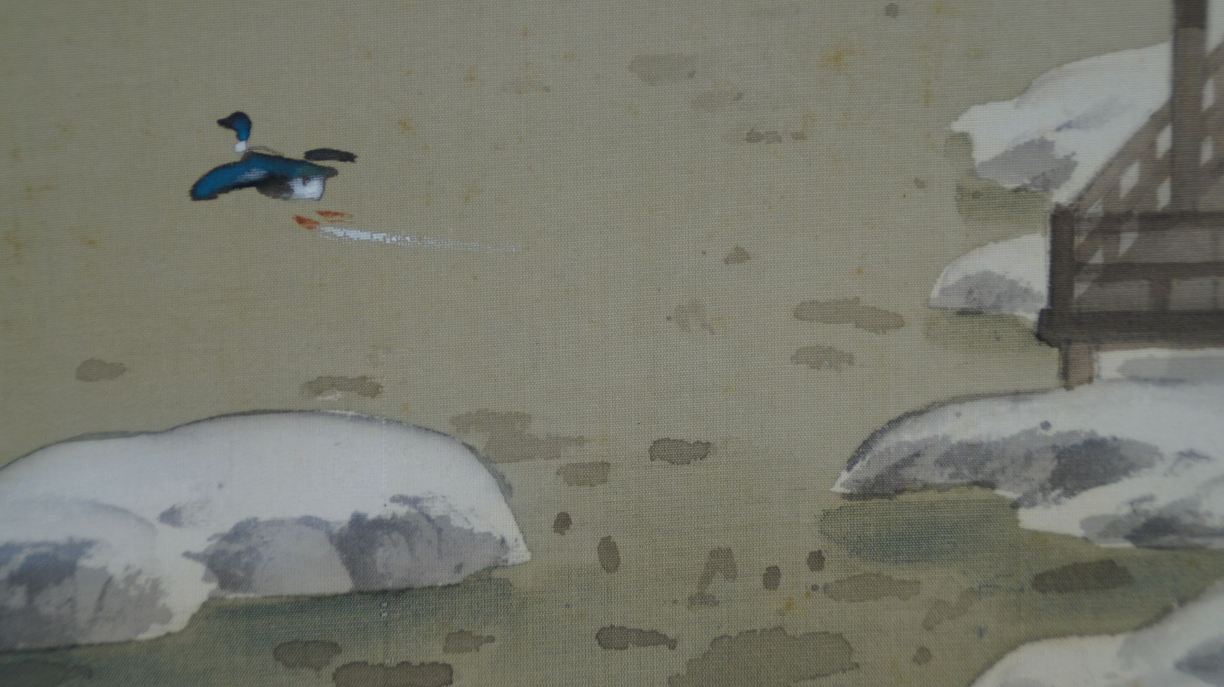 Nahaufnahme der ueber das Wasser fliegenden Ente vor schneebedeckten Steinen im Kakemono Verschneites Kloster am stillen See