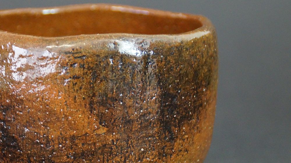 Close-up of the rim with dark glaze streaks of the chawan made of Ohi ware