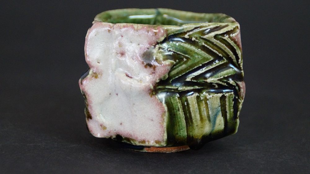 Further view of the guinomi sake cup made of Oribe ware with pink glaze stripe