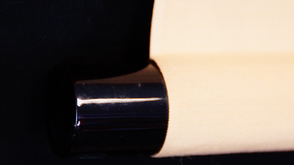 Close-up of the black-lacquered roller end of the kakemono