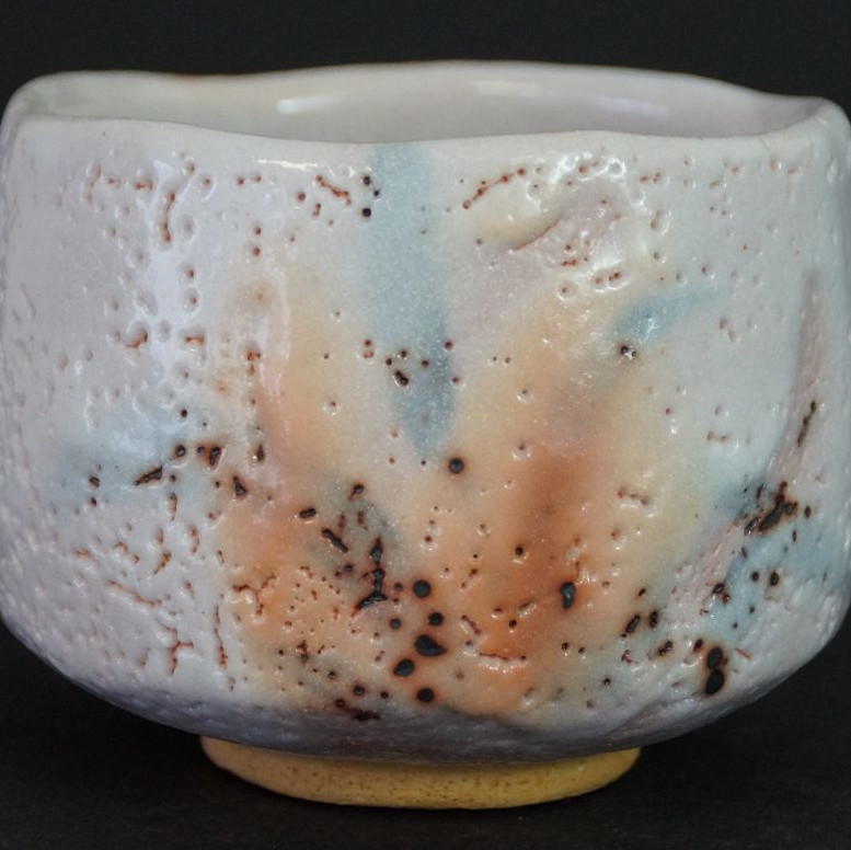 Chawan made of Shino ware by Ken Kato in full view with pastel-colored glaze in pink, blue, and orange
