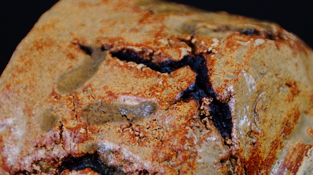 Extreme close-up of the deep fire cracks in the ochre-colored glaze of the chawan made of Seto ware by Takamichi Kato