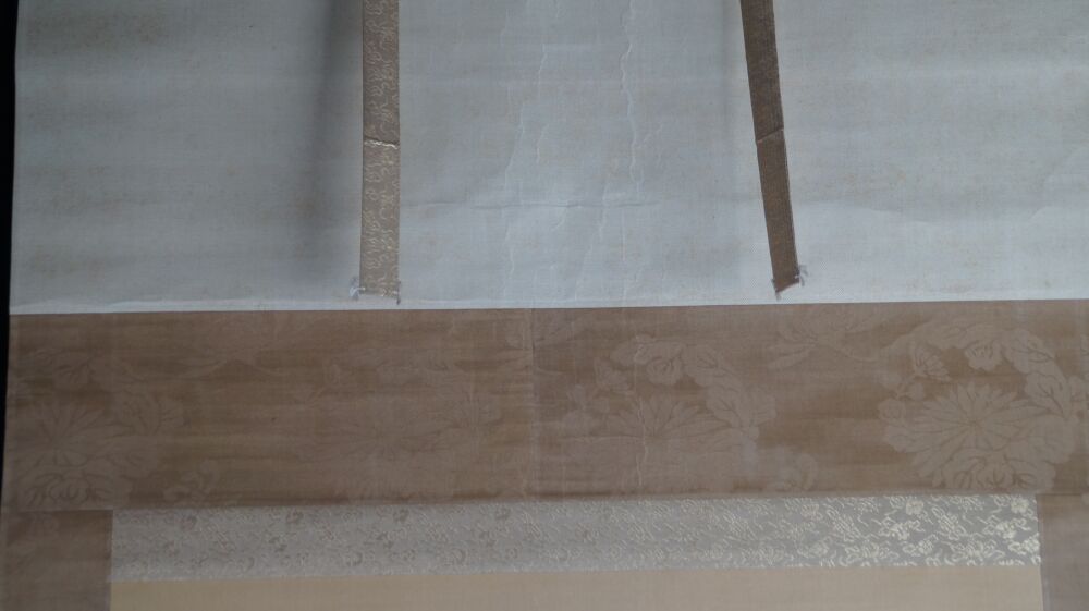 Detailansicht der cremefarbenen Seidenmontierung mit Bluetenmuster und Aufhaengebaendern des Kakemono Aufgehende Sonne
