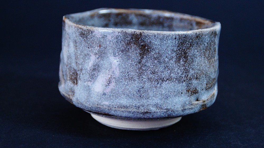 Additional side view of the chawan made of Shino ware by Kazufumi Wada with grayish-blue Nezumi-Shino glaze and dark iron spots