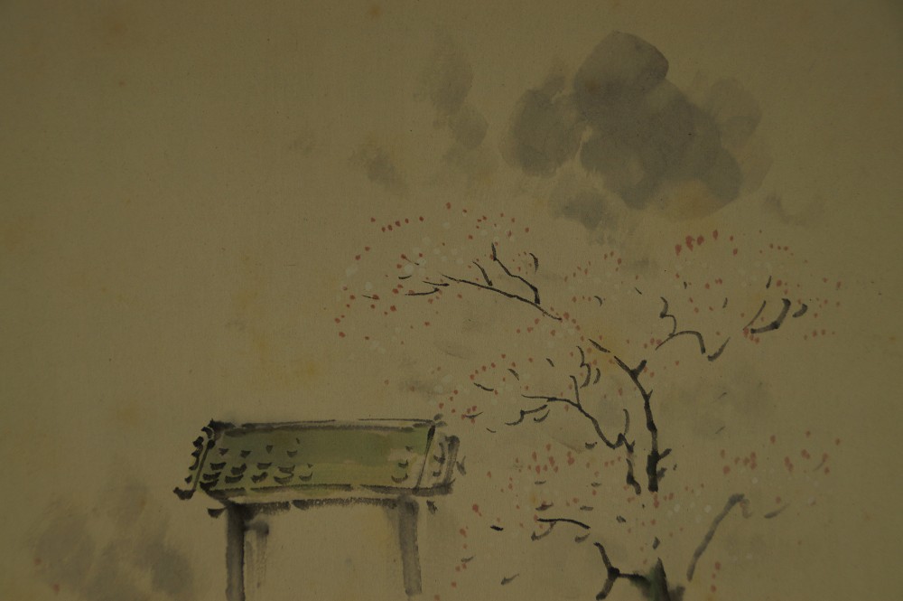 Nahaufnahme des Torii-Dachs vor der Tuschewolke und dem bluehenden Baum