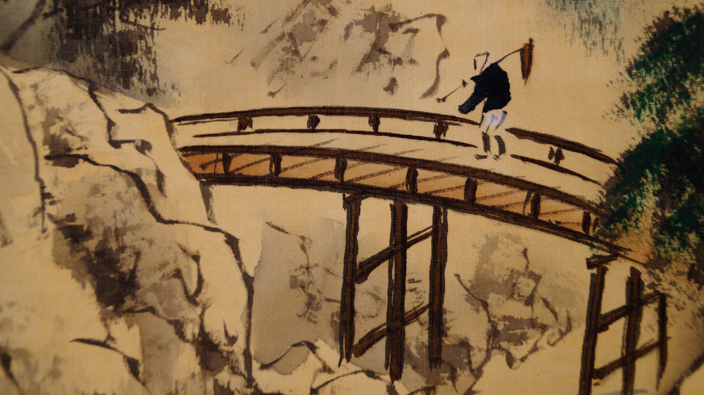 Extreme Nahaufnahme des ueber die Bruecke schreitenden Wanderers mit Gepaeck und Wanderstab im Kakemono Landschaft mit Fuji von Suido