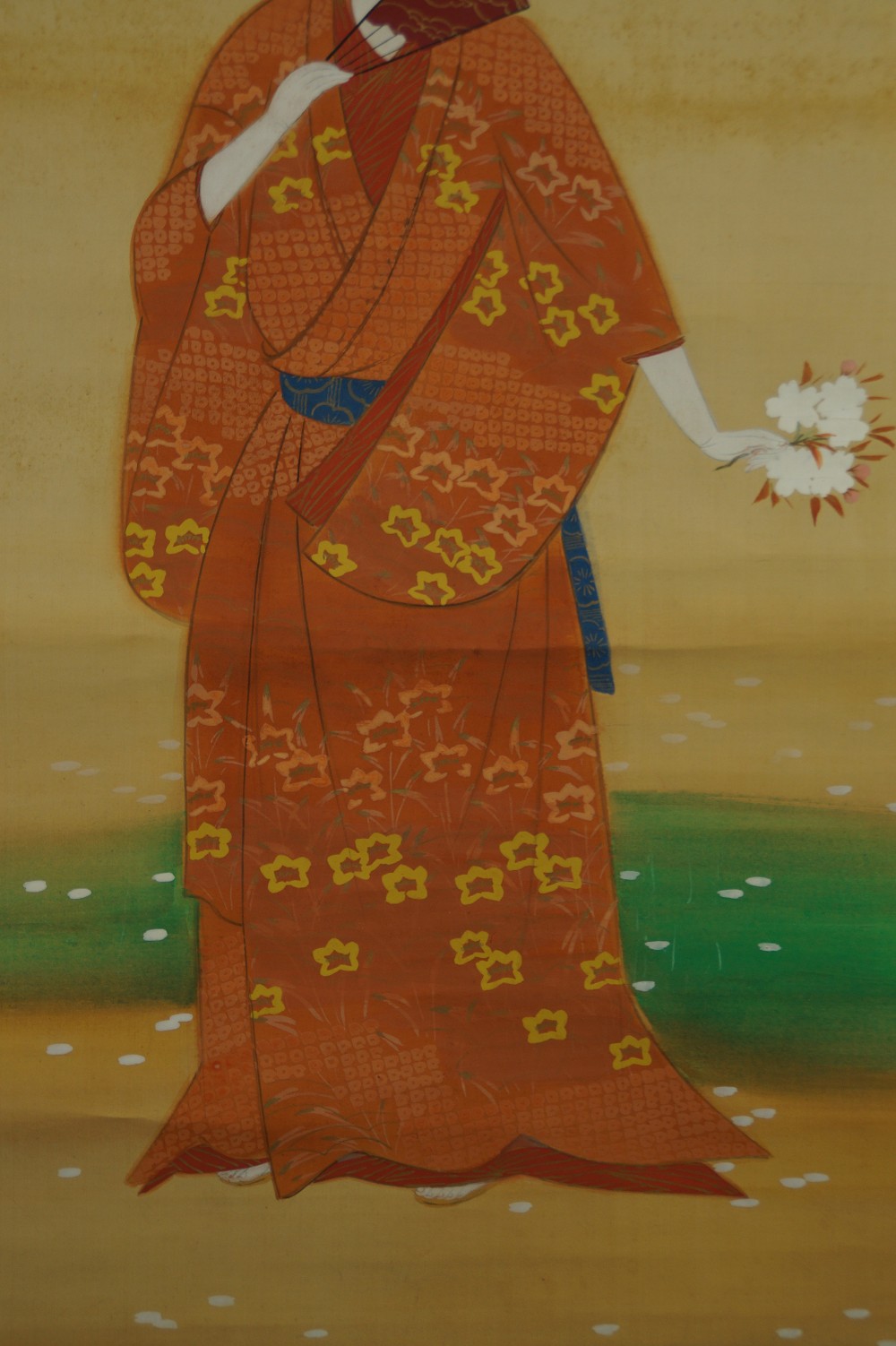 Close-up of the elaborately patterned orange kimono with blue obi